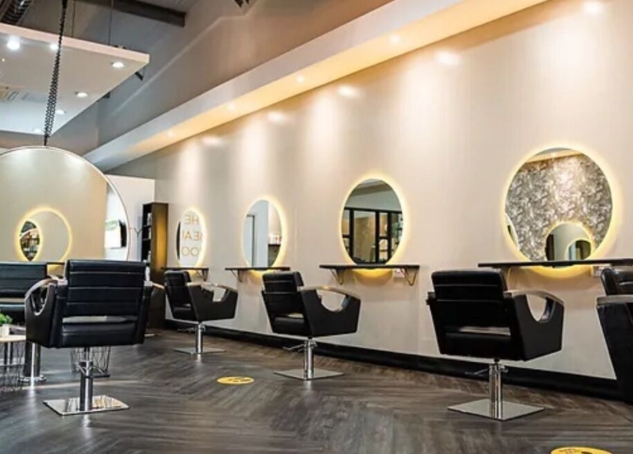 Modern salon interior at Steadman & Co, Peterborough, England, GB with sleek chairs and illuminated mirrors.