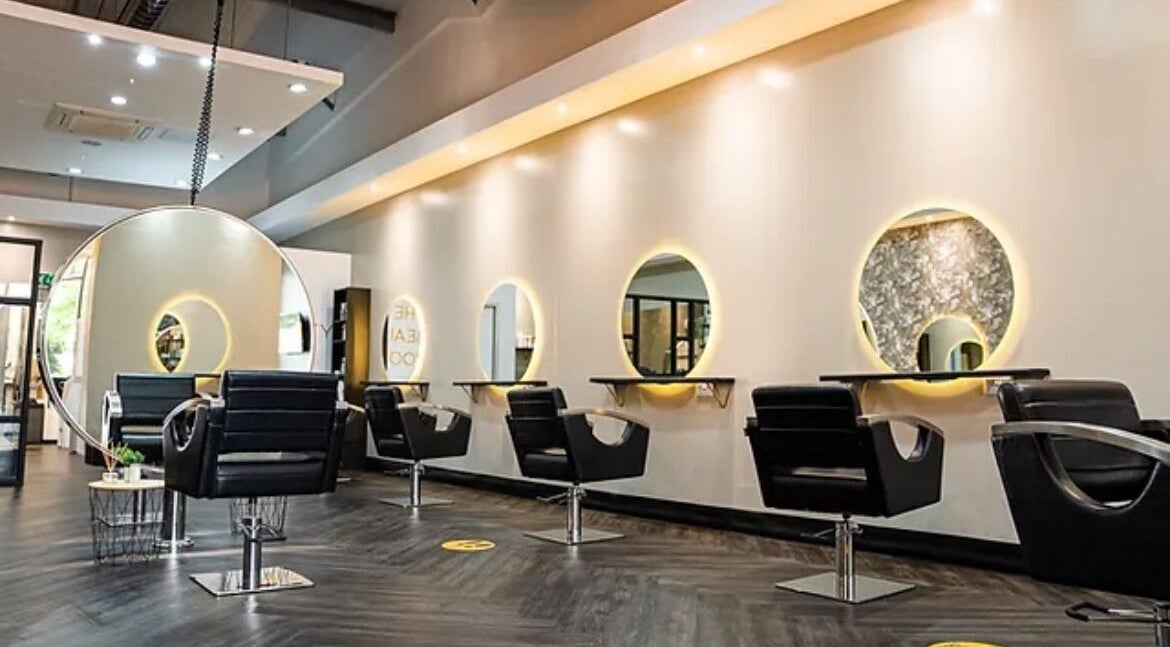 Modern salon interior at Steadman & Co, Peterborough, England, GB with sleek chairs and illuminated mirrors.