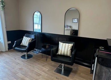 Chic seating area at Ashleigh Lauren Hair in Kircubbin, Northern Ireland, GB, featuring modern mirrors and chairs.