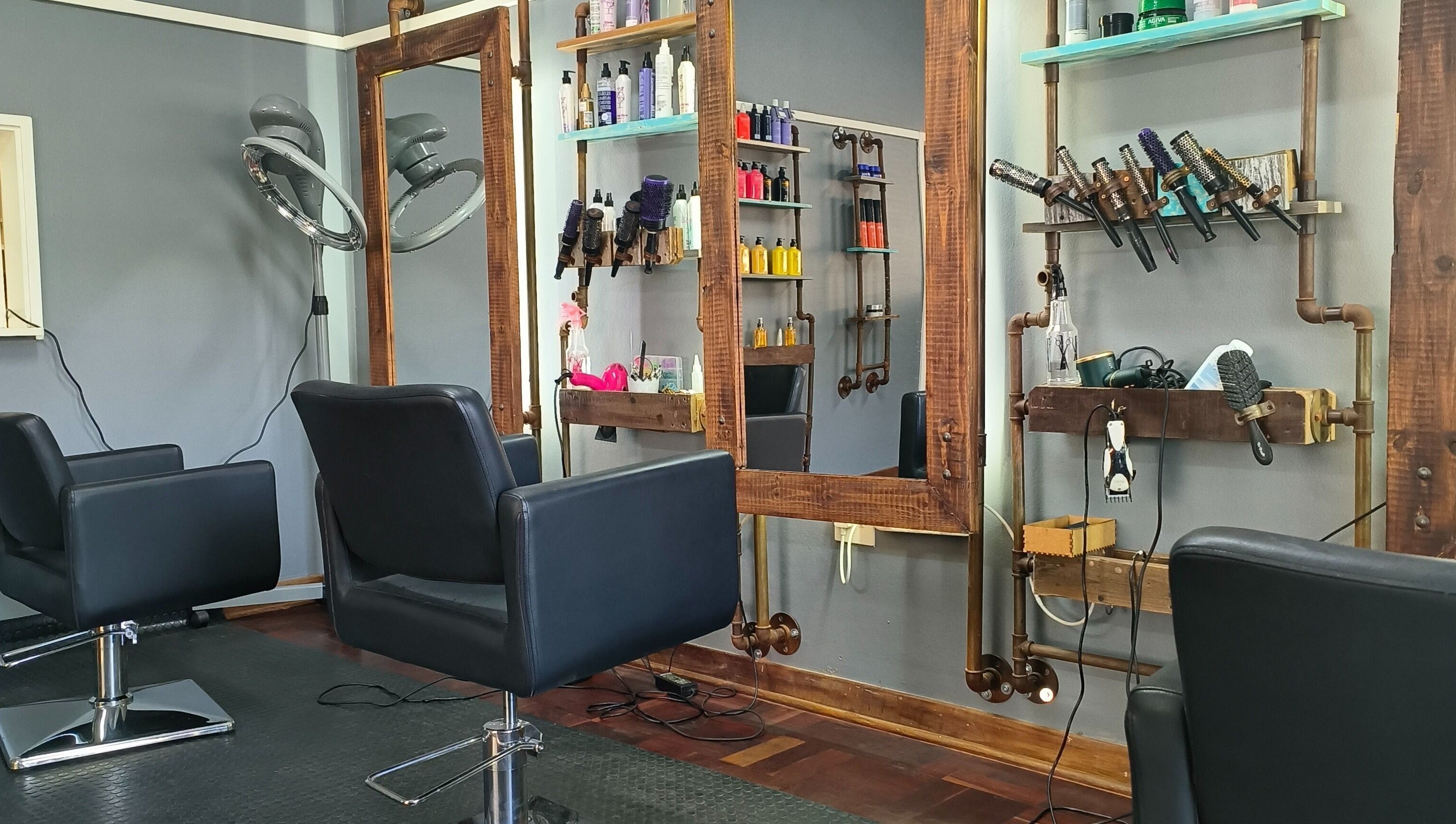 Elegant styling stations at Revive Hair Studio in Rustenburg, North West, ZA, showcasing sleek chairs and products.