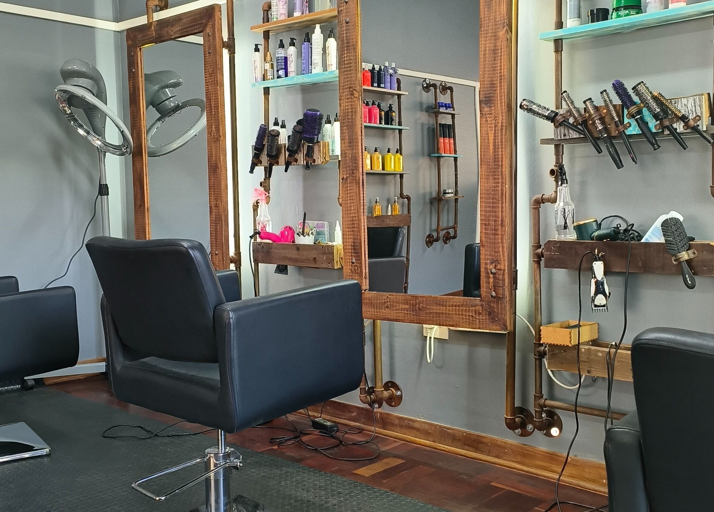 Elegant styling stations at Revive Hair Studio in Rustenburg, North West, ZA, showcasing sleek chairs and products.