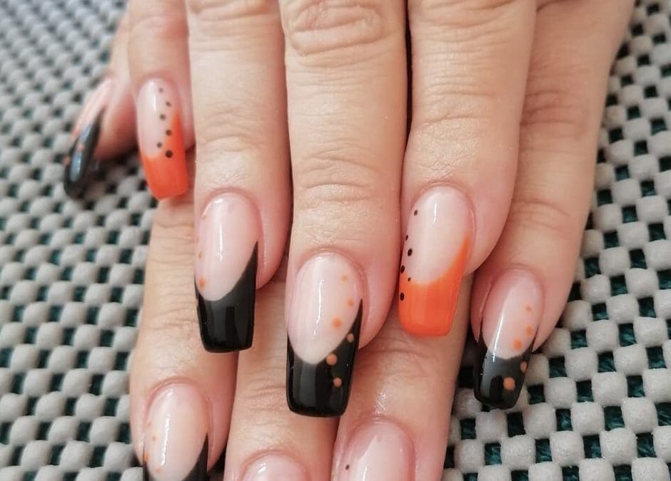 Stylish orange and black nail design at Revive Hair Studio in Rustenburg, North West, ZA.