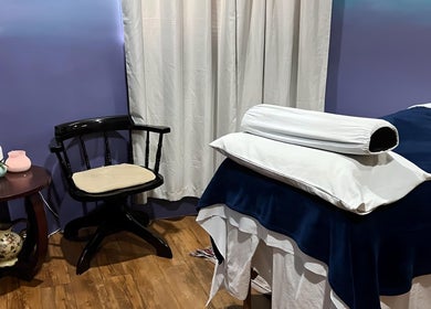 Tranquil massage room at Elysion Therapies in Carapo, Tunapuna/piarco Regional Corporation, TT with cozy chair and table.