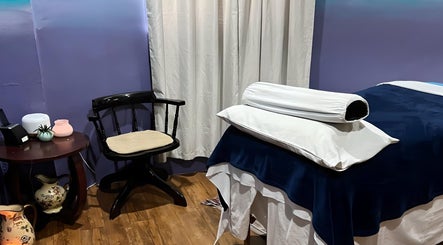 Tranquil massage room at Elysion Therapies in Carapo, Tunapuna/piarco Regional Corporation, TT with cozy chair and table.