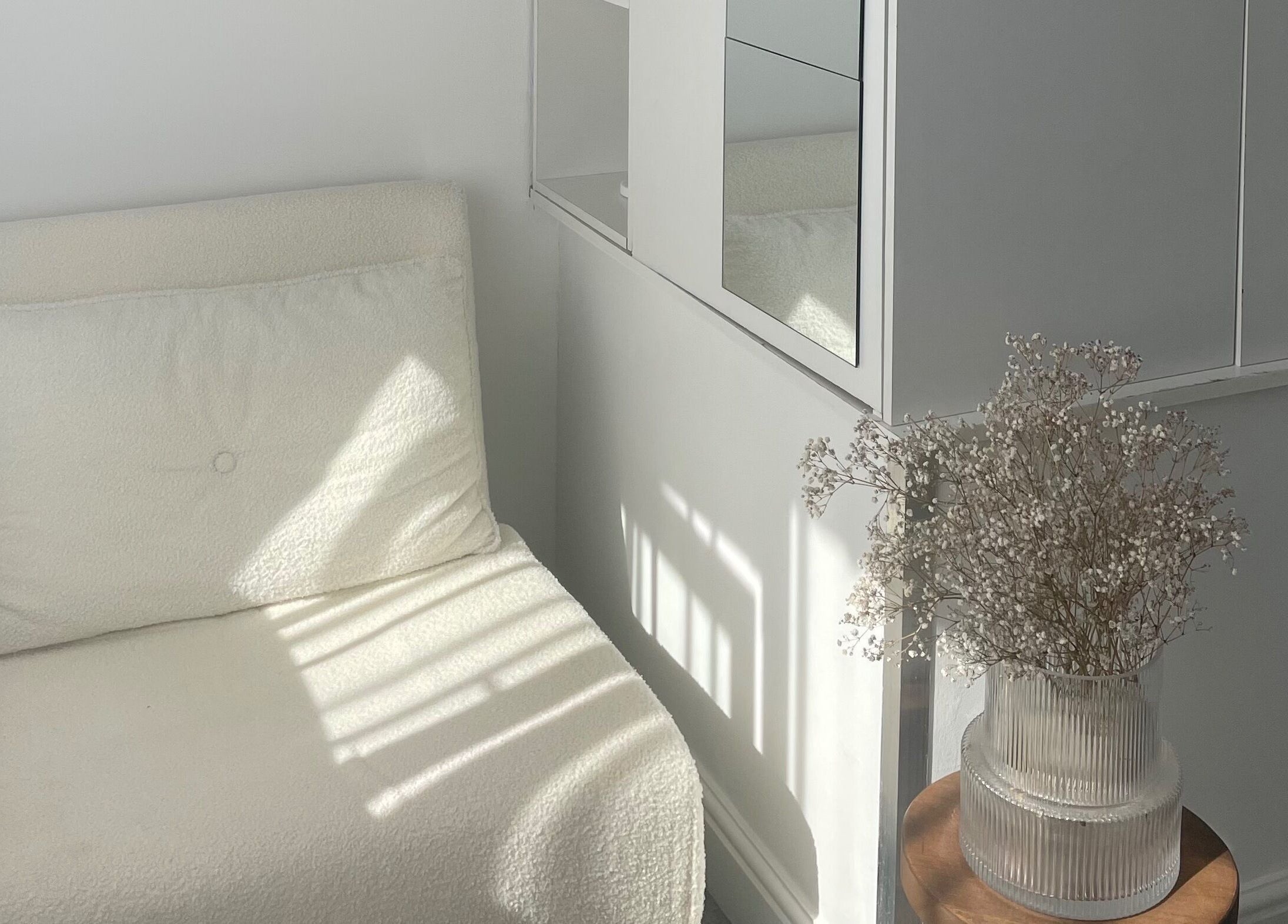 Bright, minimalist seating area at Tahliah Nails in Hull, England, GB with white decor and elegant vase.