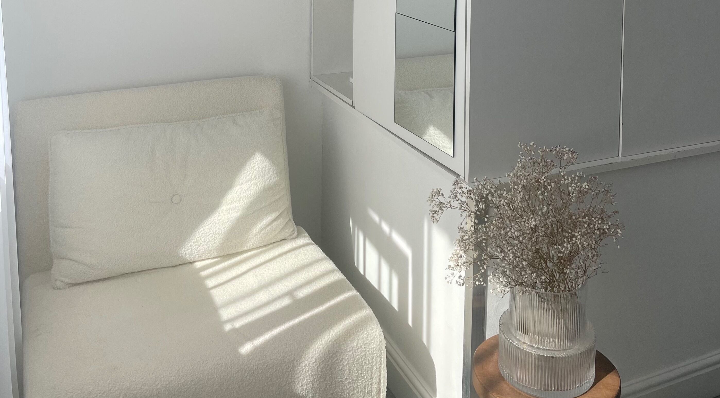 Bright, minimalist seating area at Tahliah Nails in Hull, England, GB with white decor and elegant vase.