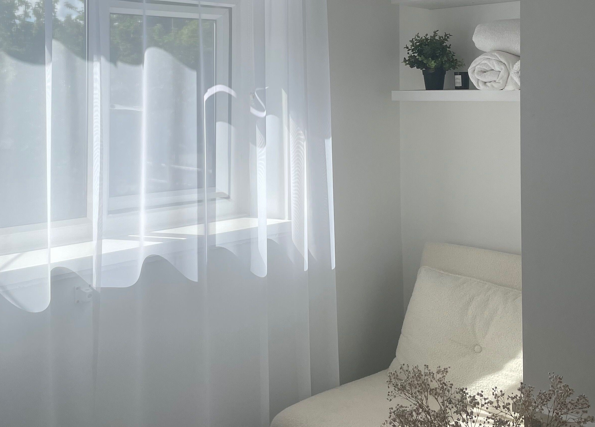 Bright, minimalist space at Tahliah Nails in Hull, England featuring soft white chair and delicate decor.