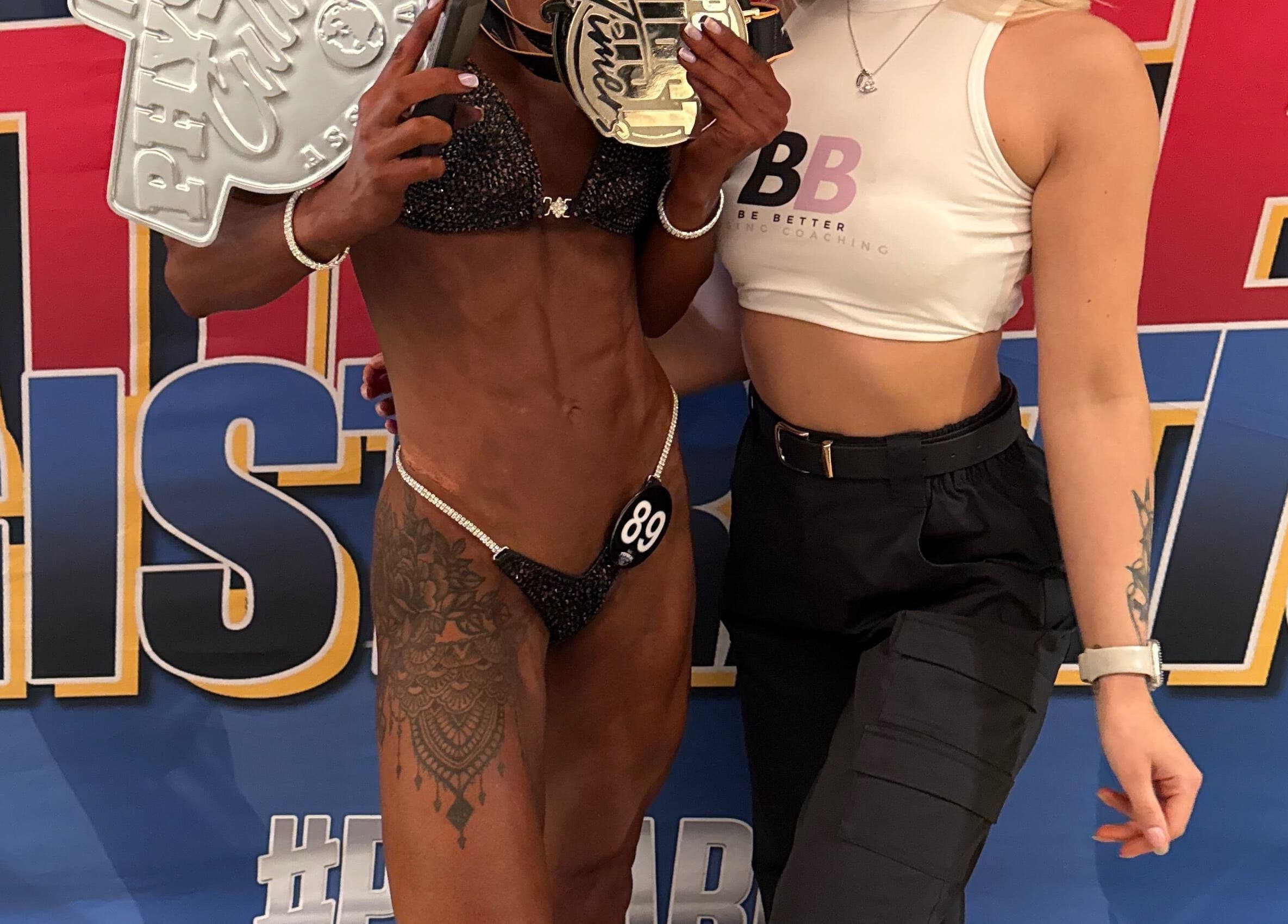 Champion at Be Better Posing Coaching event, Coventry, England, GB, displaying a trophy with a trainer.