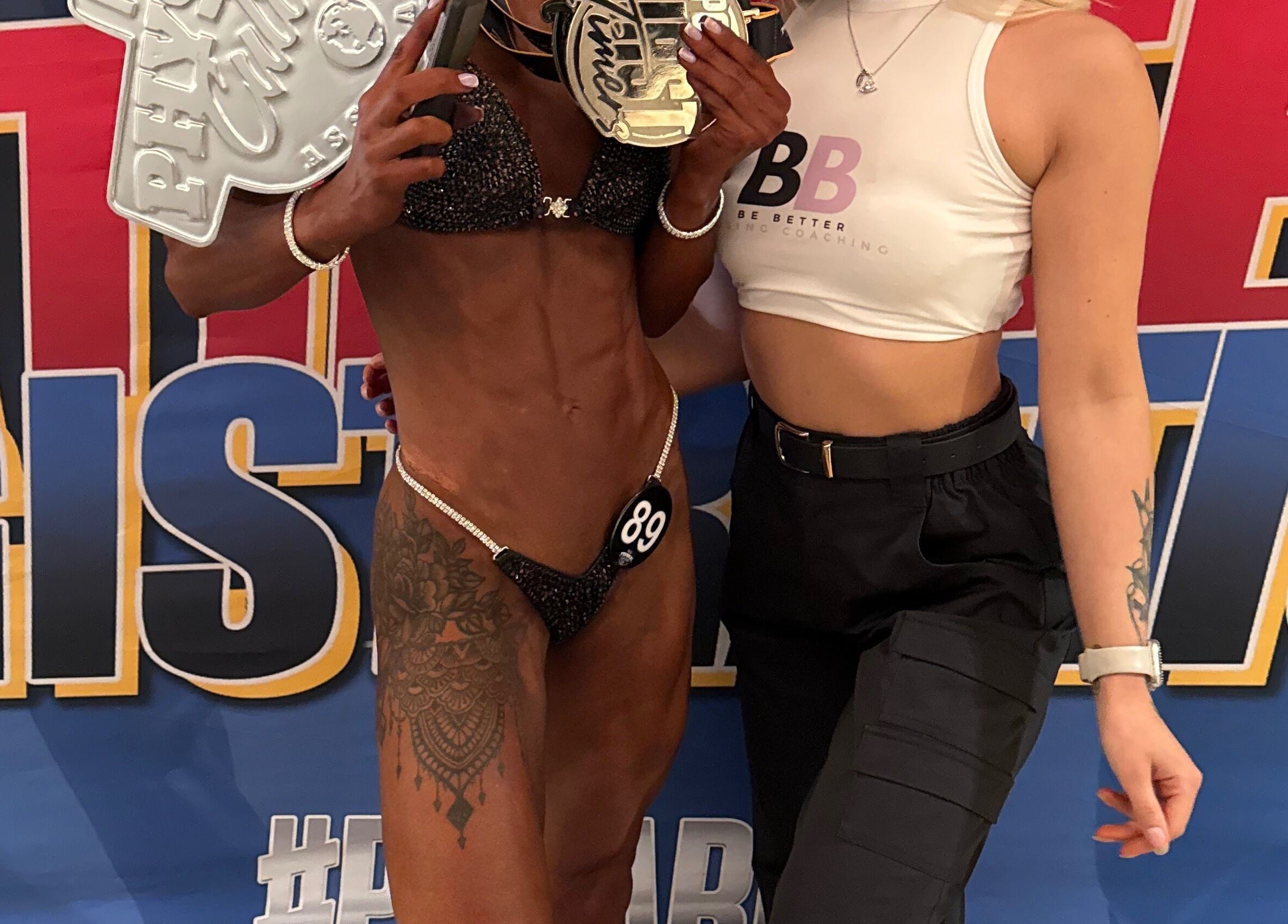 Champion at Be Better Posing Coaching event, Coventry, England, GB, displaying a trophy with a trainer.