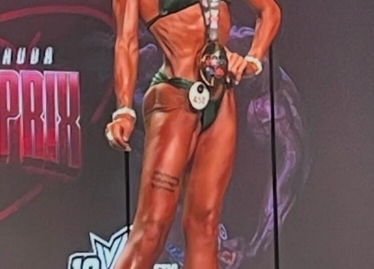 Bodybuilder on stage at Be Better Posing Coaching, Coventry, England, GB showcasing perfect physique.