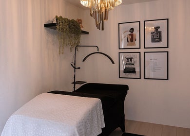 Moderne behandelkamer bij Glamz studio in Almere, Flevoland, NL met kunst en elegante verlichting.