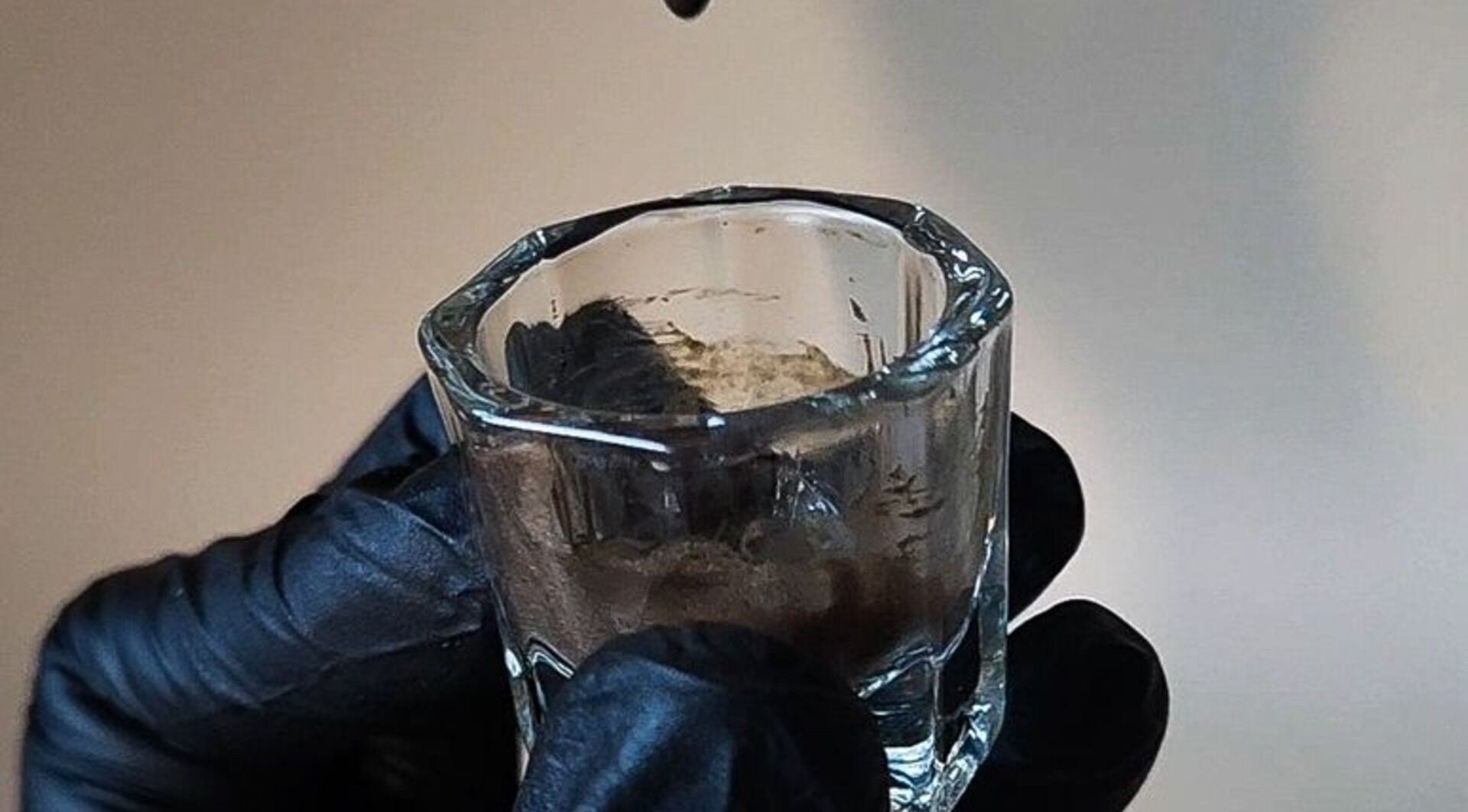 Hydratatiebehandeling bij Glamz studio in Almere, Flevoland, NL. Glazen potje onder gloved handen.