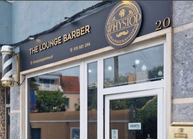 Fachada da Why Stop Barber Shop Algés, localizada em Algés, Lisboa, PT, destacando a entrada e placa.
