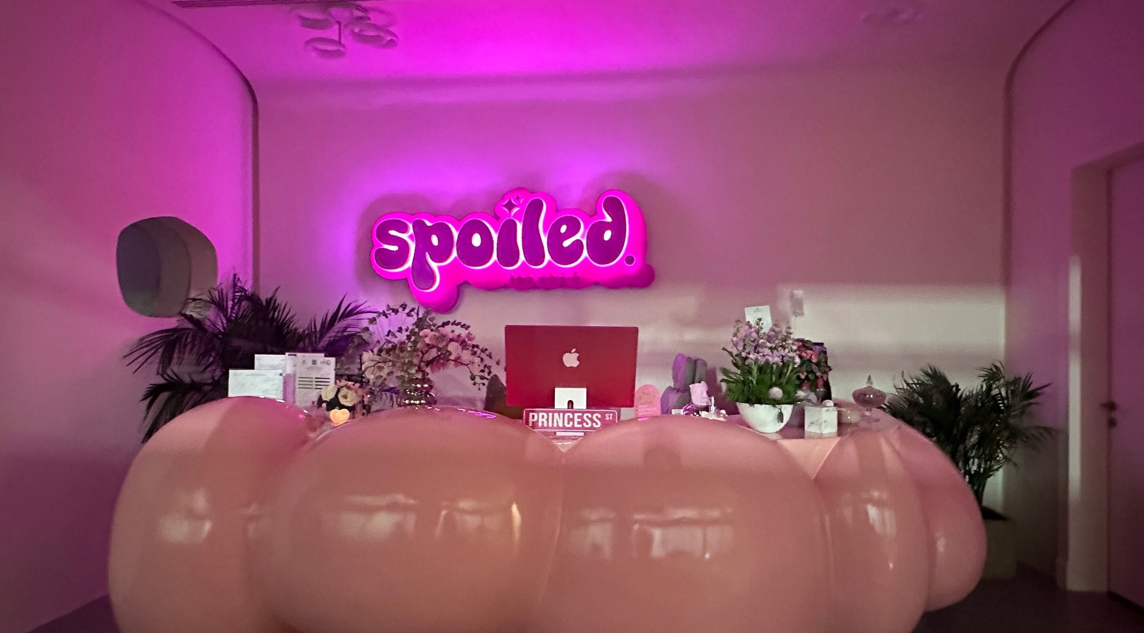 Stylish reception at Spoiled Nail Studio, Riyadh, Riyadh Province, SA with pink signage and modern decor.