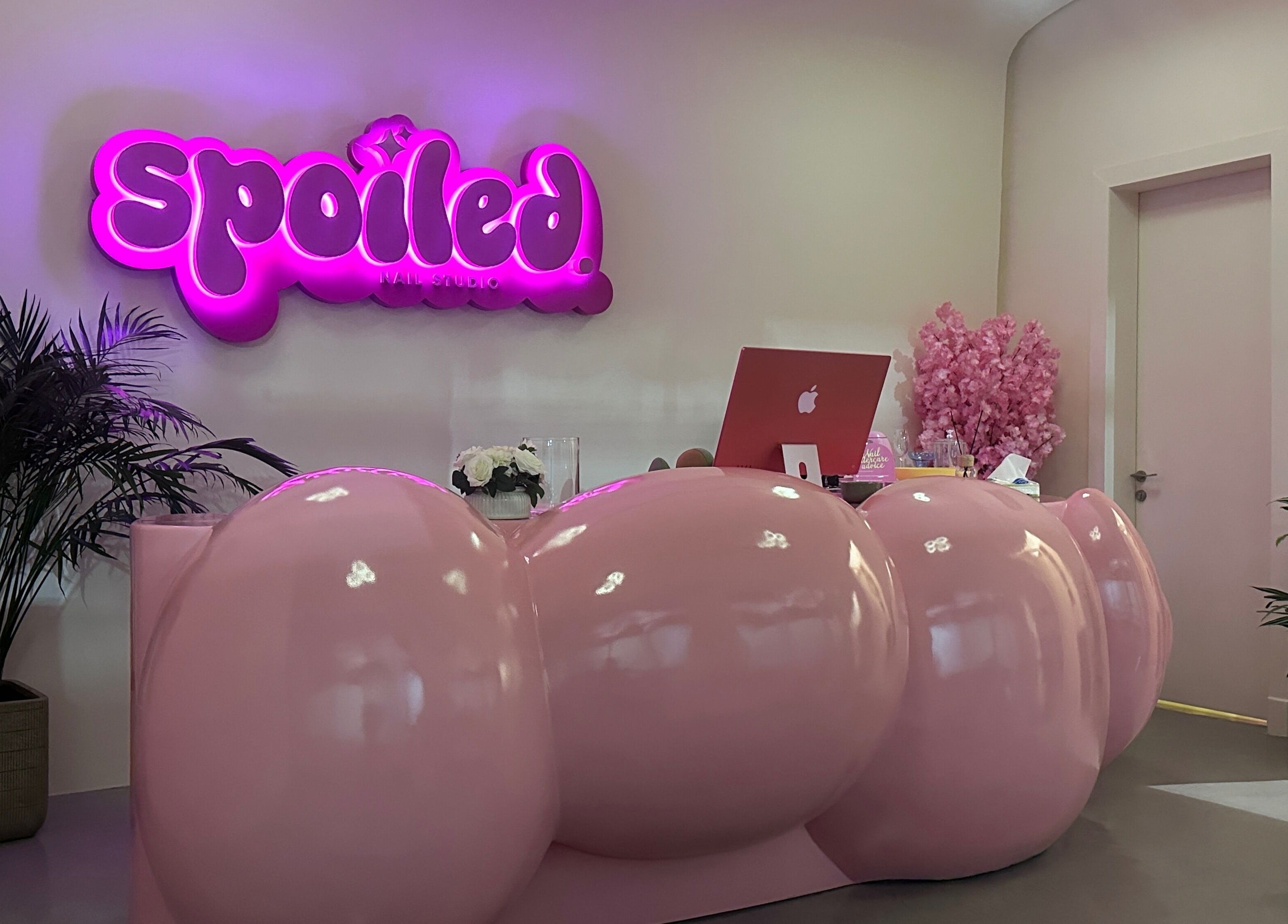 Vibrant reception at Spoiled Nail Studio, Riyadh, Riyadh Province, SA with pink decor and glowing signage.