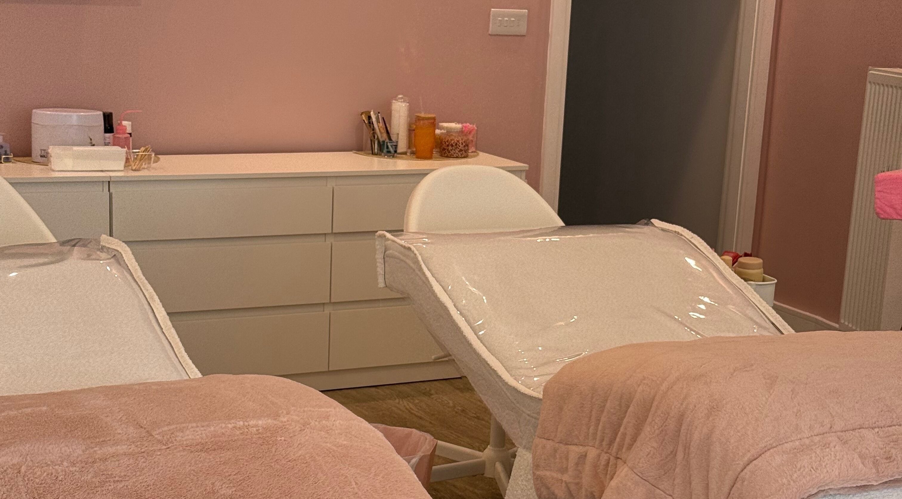 Cozy treatment room at Beauty by Ella Neal, Burnley, England, GB with soft pink decor and plush chairs.