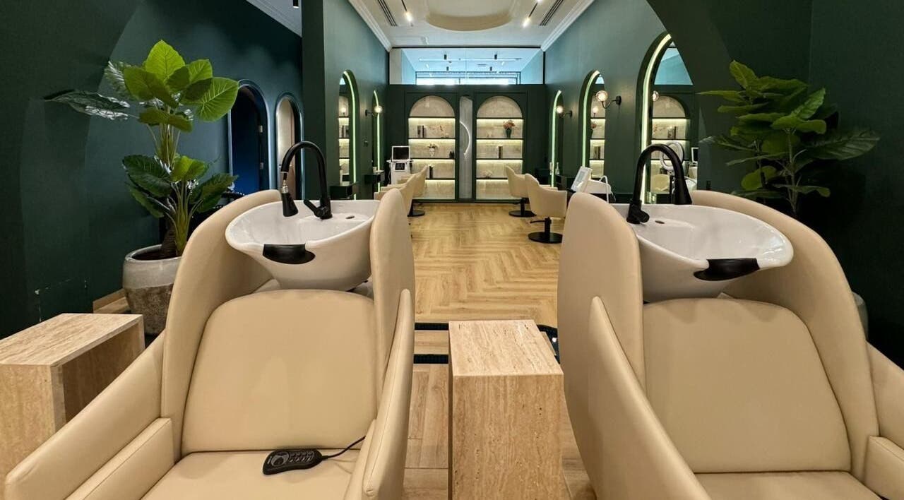 Elegant interior of Promise Hair Spa in Dubai, Dubai, AE, showcasing stylish wash stations and lush greenery.