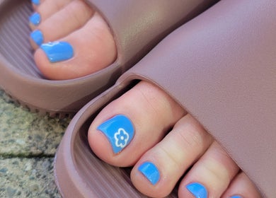Bright blue pedicure with flower at Formation Beauty Lounge, Vancouver, British Columbia, CA.