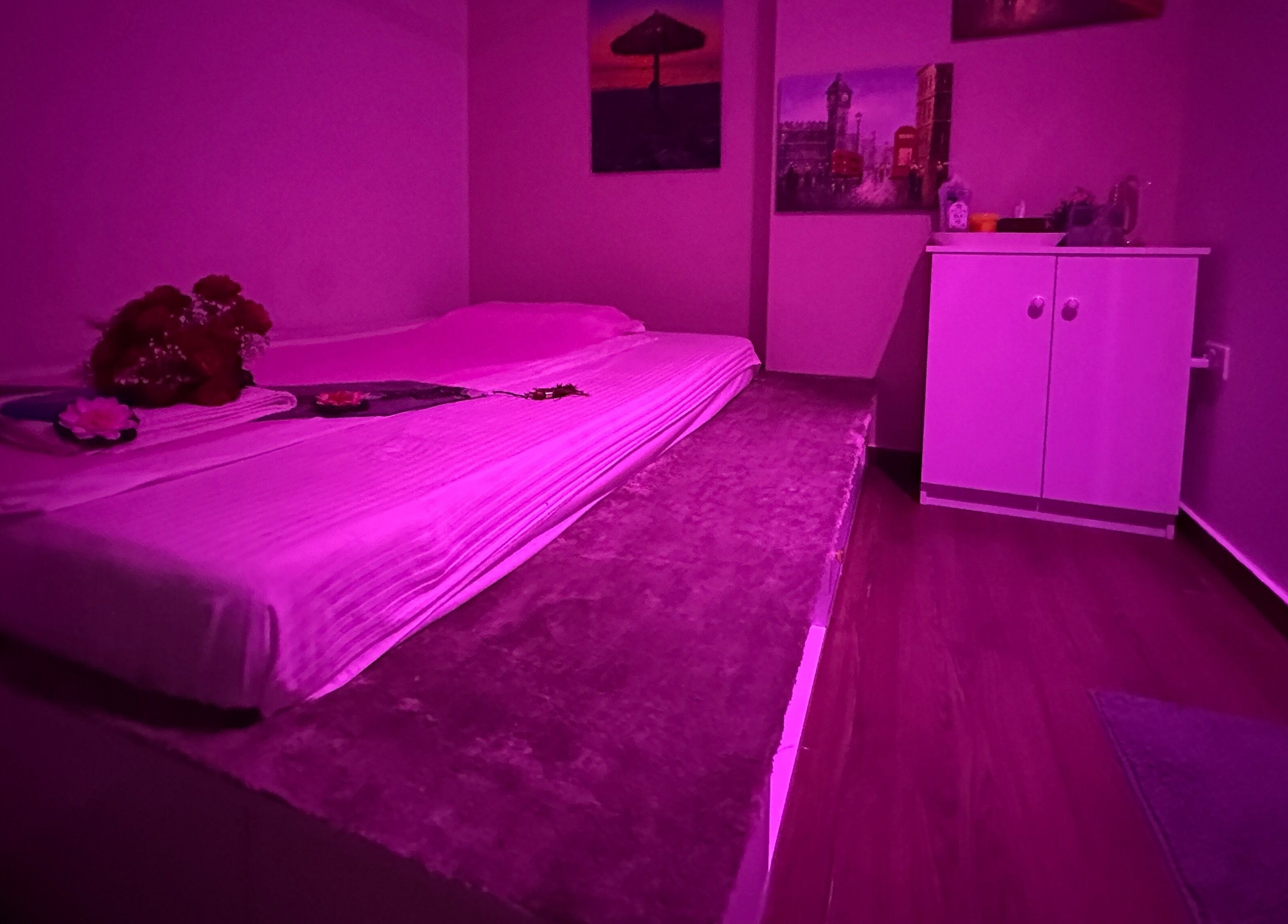 Cozy massage room at L and Y Salon and SPA for Man - Musaffah Massage in Abu Dhabi, AE with a calming pink glow.