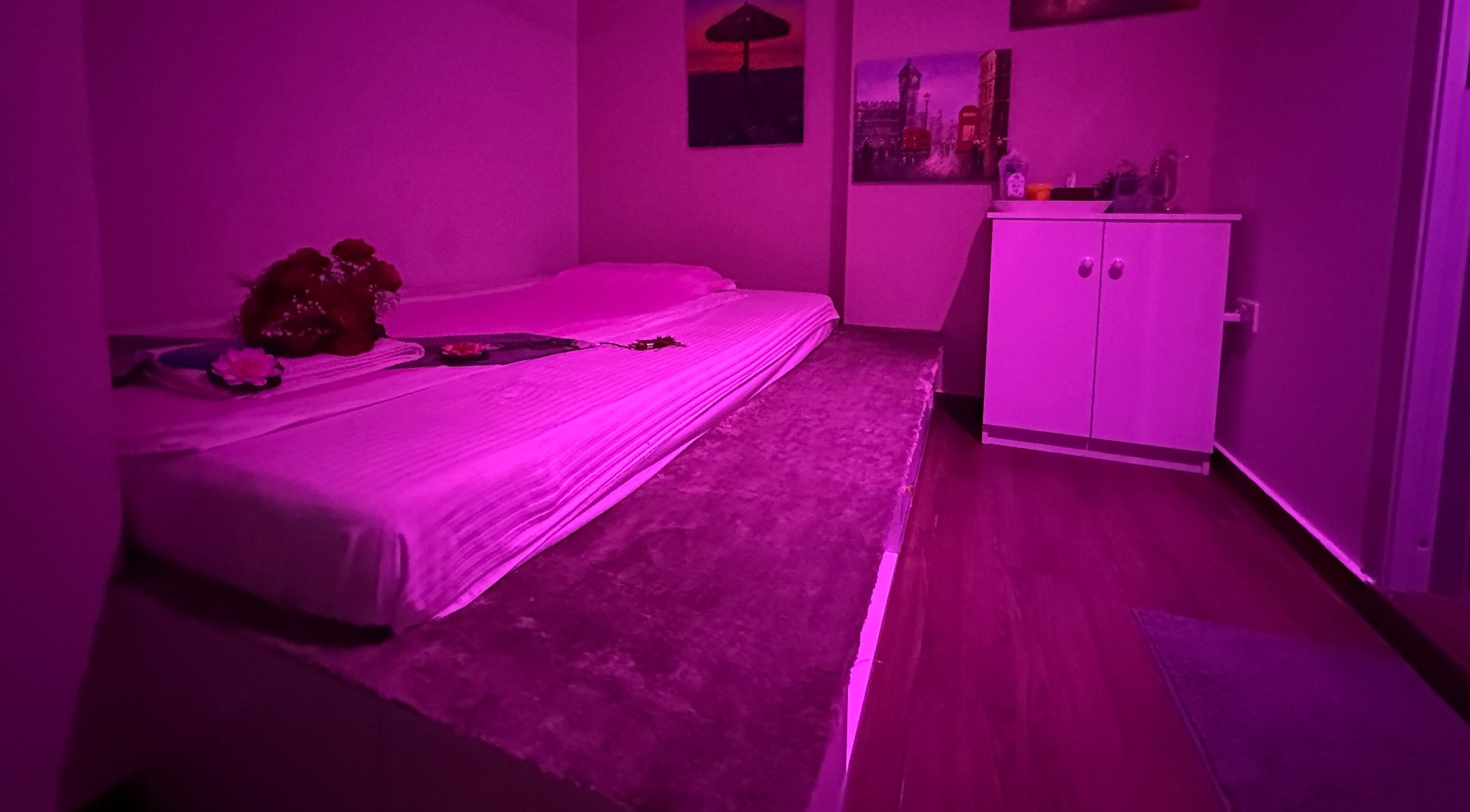 Cozy massage room at L and Y Salon and SPA for Man - Musaffah Massage in Abu Dhabi, AE with a calming pink glow.