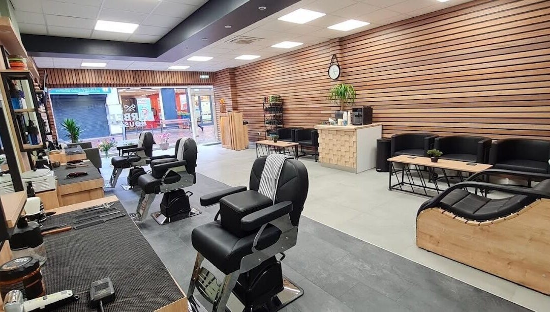 Stijlvol interieur van BarberHouse, gelegen in Ede, Gelderland, NL met moderne kappersstoelen en houtaccenten.