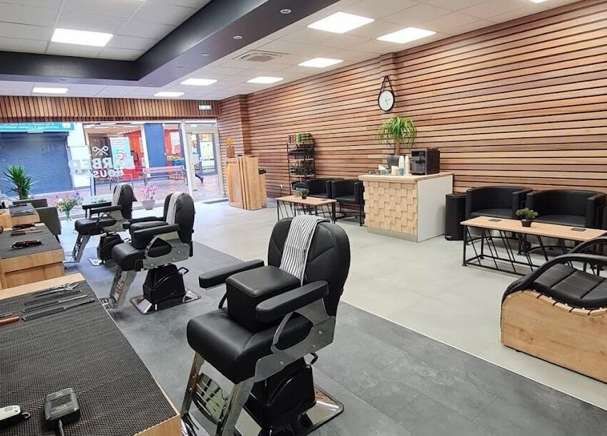 Stijlvol interieur van BarberHouse, gelegen in Ede, Gelderland, NL met moderne kappersstoelen en houtaccenten.