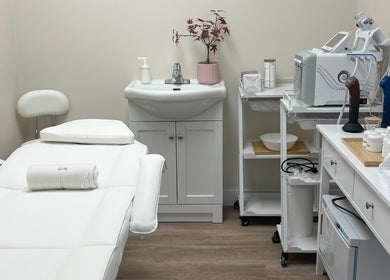 Tranquil spa room at Oasis Aesthetics Spa - Ness in Winnipeg, Manitoba, CA showcasing a treatment bed and equipment.