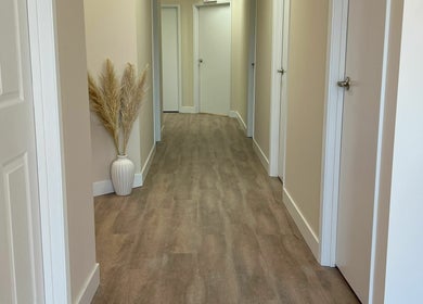 Modern hallway at Oasis Aesthetics Spa - Ness in Winnipeg, Manitoba, CA, featuring sleek decor and soft lighting.