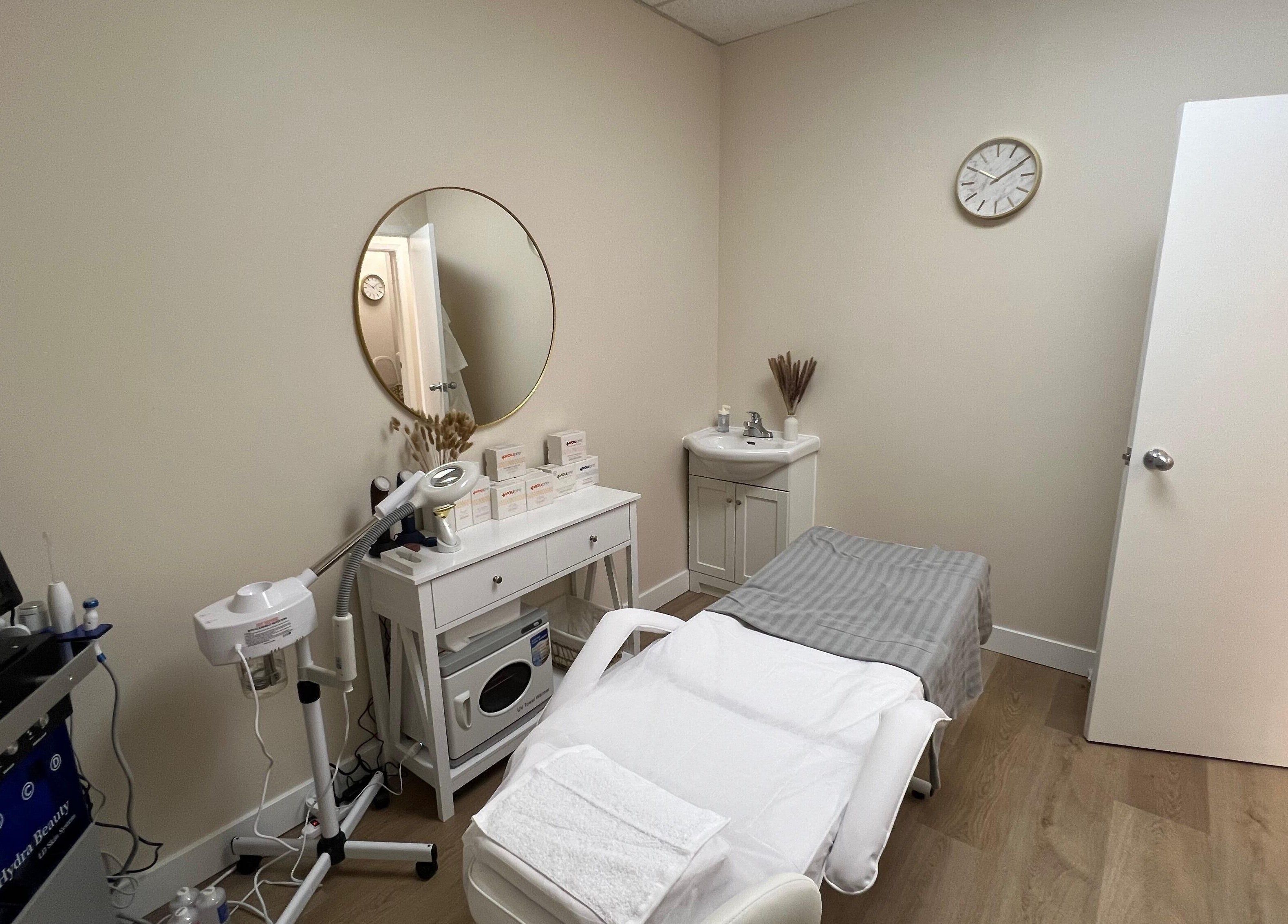 Treatment room at Oasis Aesthetics Spa - Henderson in Winnipeg, Manitoba, CA with massage bed and equipment.