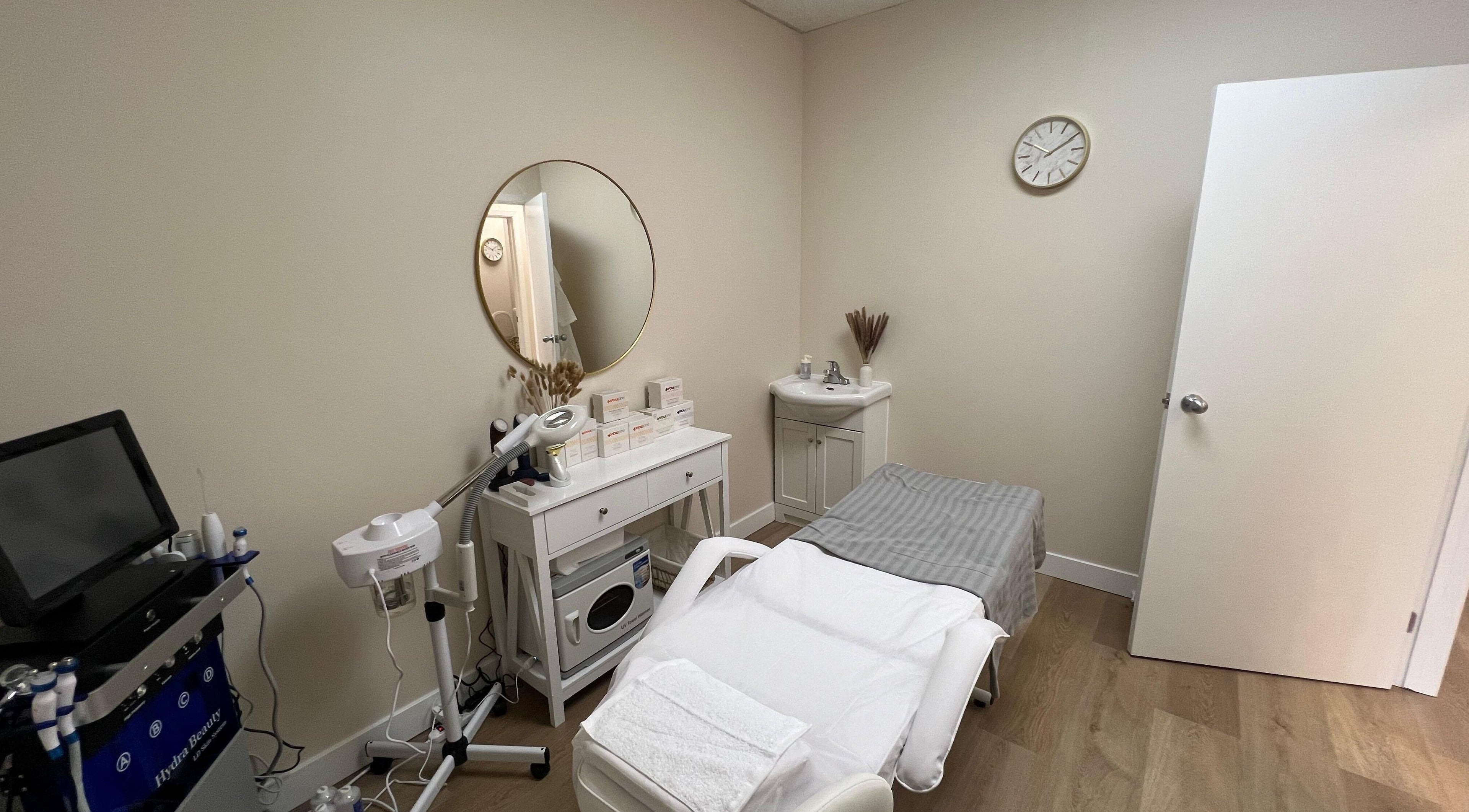 Treatment room at Oasis Aesthetics Spa - Henderson in Winnipeg, Manitoba, CA with massage bed and equipment.