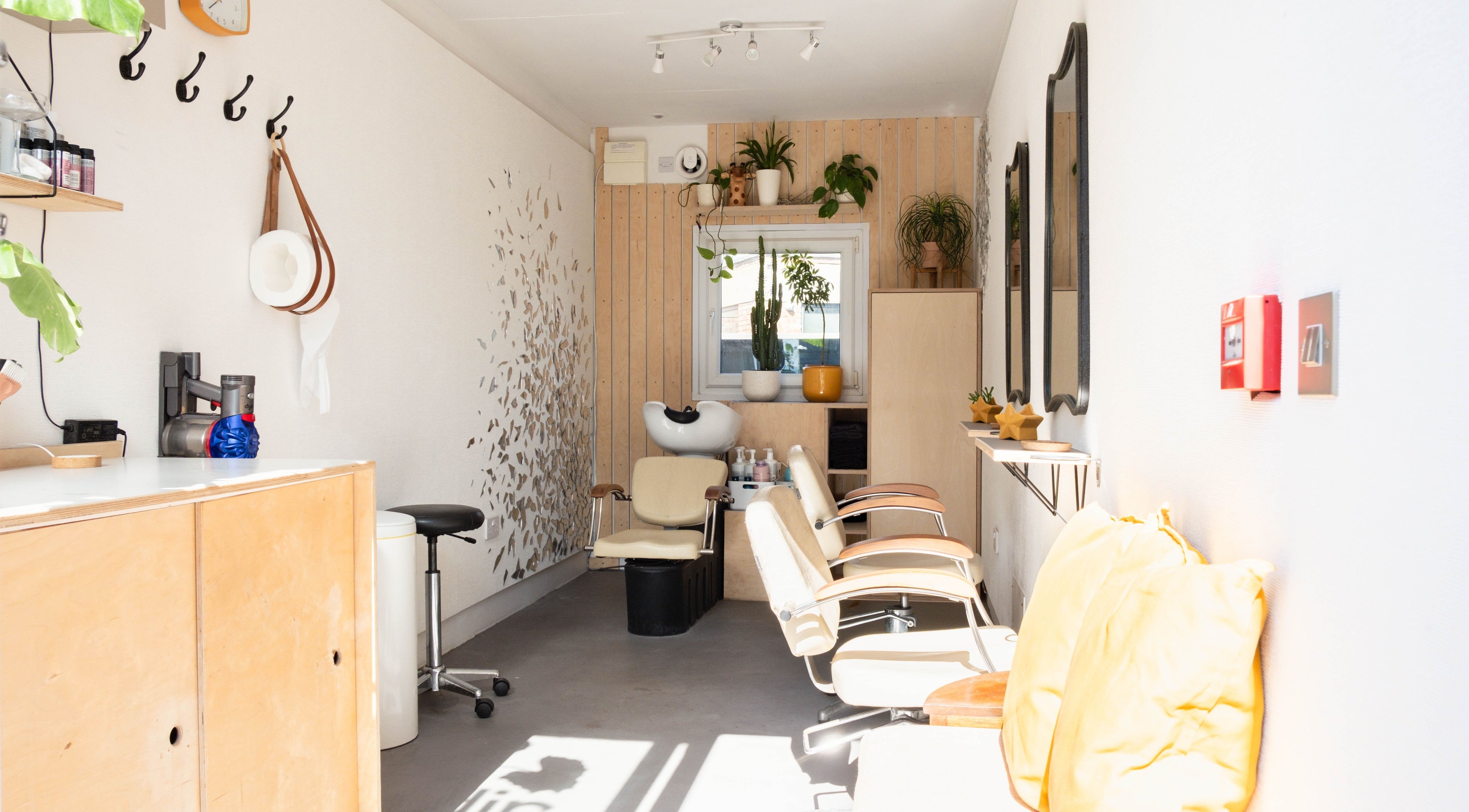 Klip London salon in London, England, GB, showcasing chic interior with elegant styling chairs and plant décor.