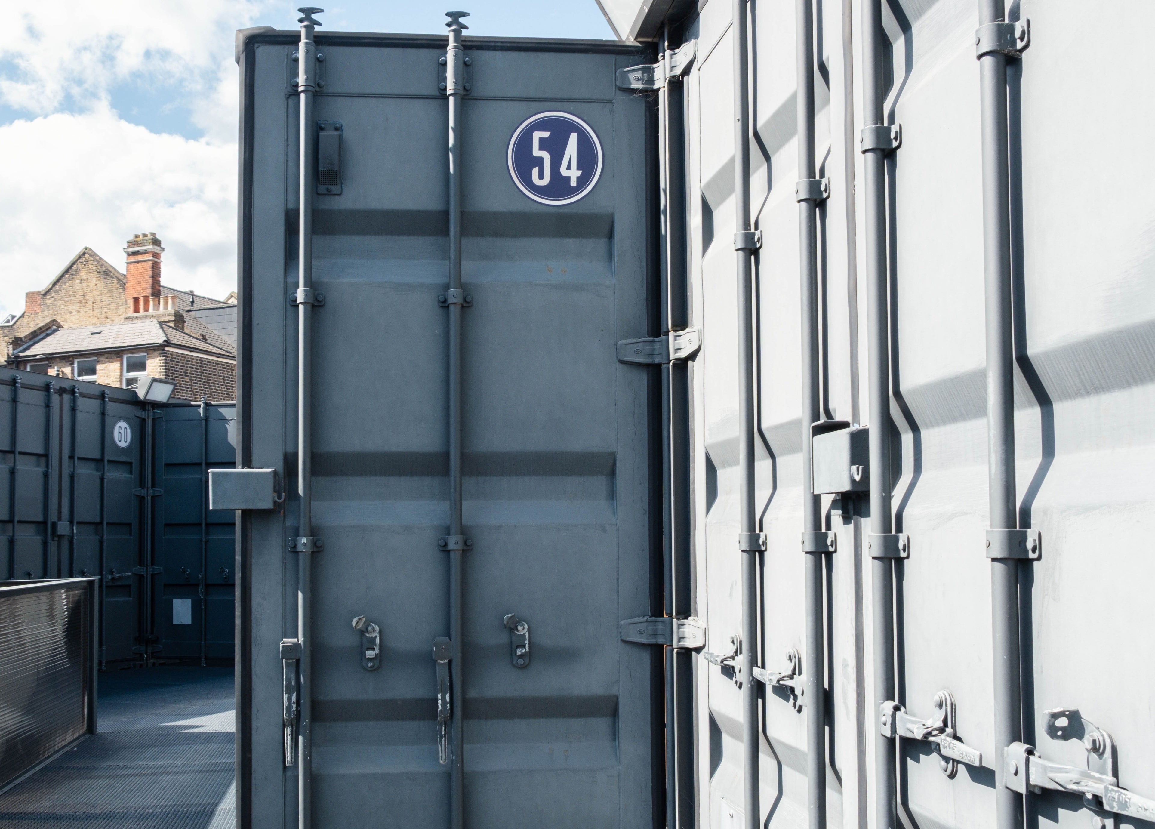 Industrial-style containers at Klip London in London, England, GB under a cloudy sky.