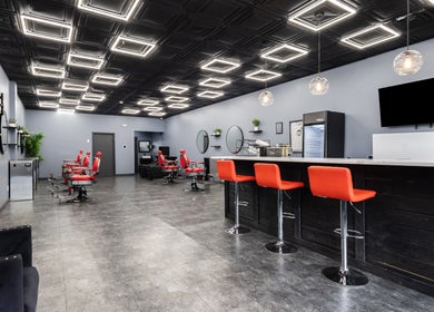 Modern salon interior at YuroCuts Garnerville, Mount Ivy, New York, with stylish decor and red chairs.