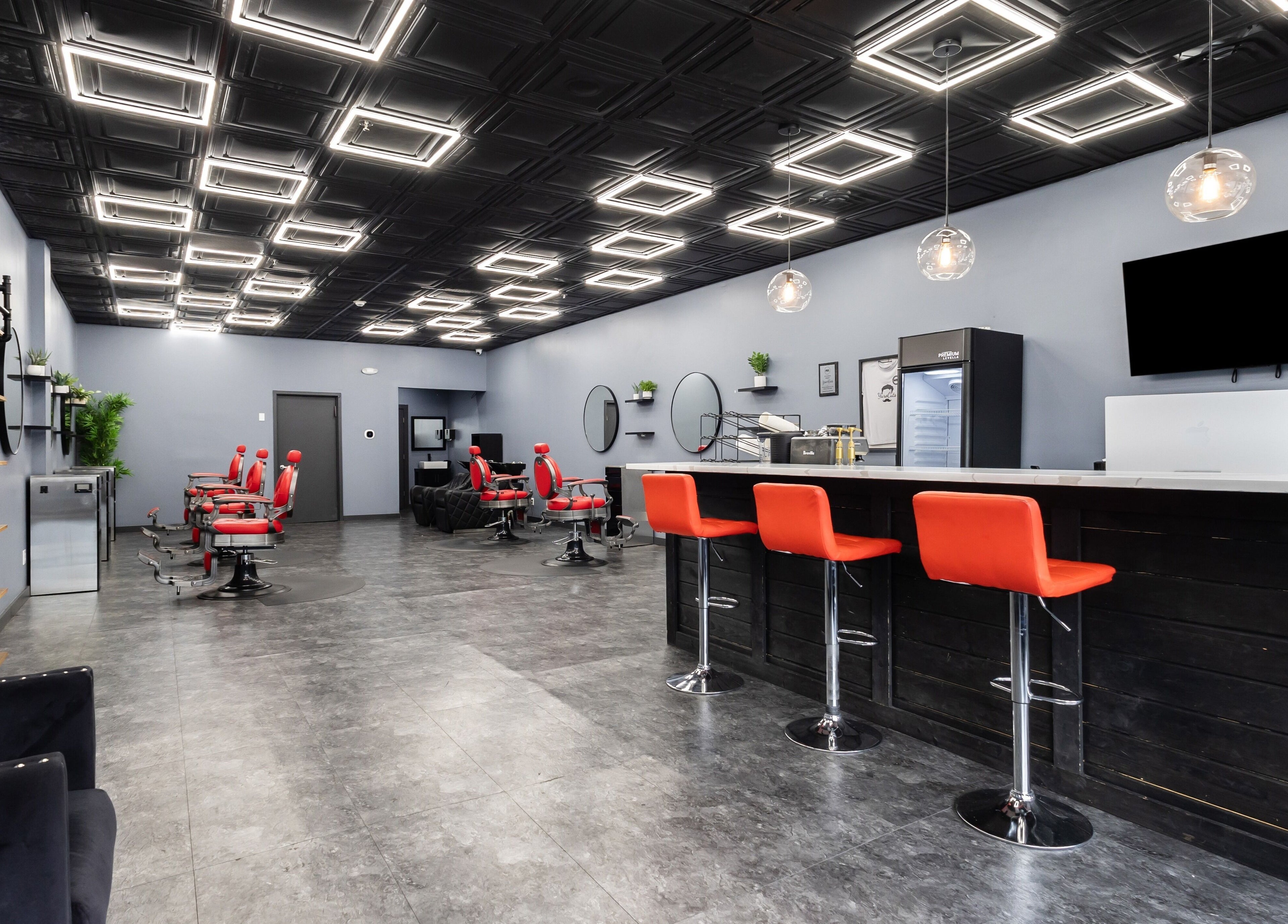 Modern salon interior at YuroCuts Garnerville, Mount Ivy, New York, with stylish decor and red chairs.