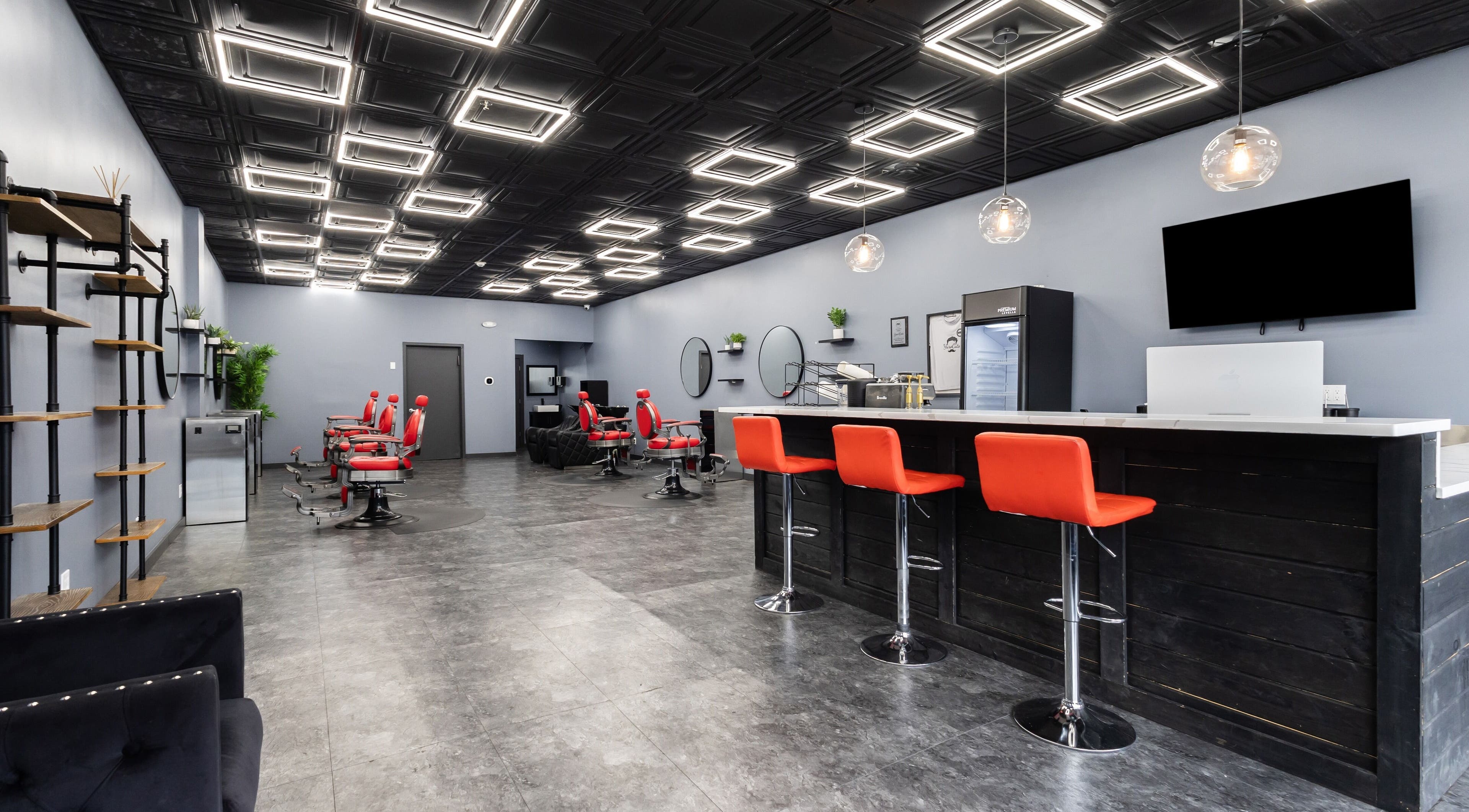 Modern salon interior at YuroCuts Garnerville, Mount Ivy, New York, with stylish decor and red chairs.