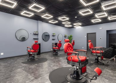 Modern salon interior at YuroCuts Garnerville, Mount Ivy, New York, US featuring red chairs and sleek decor.