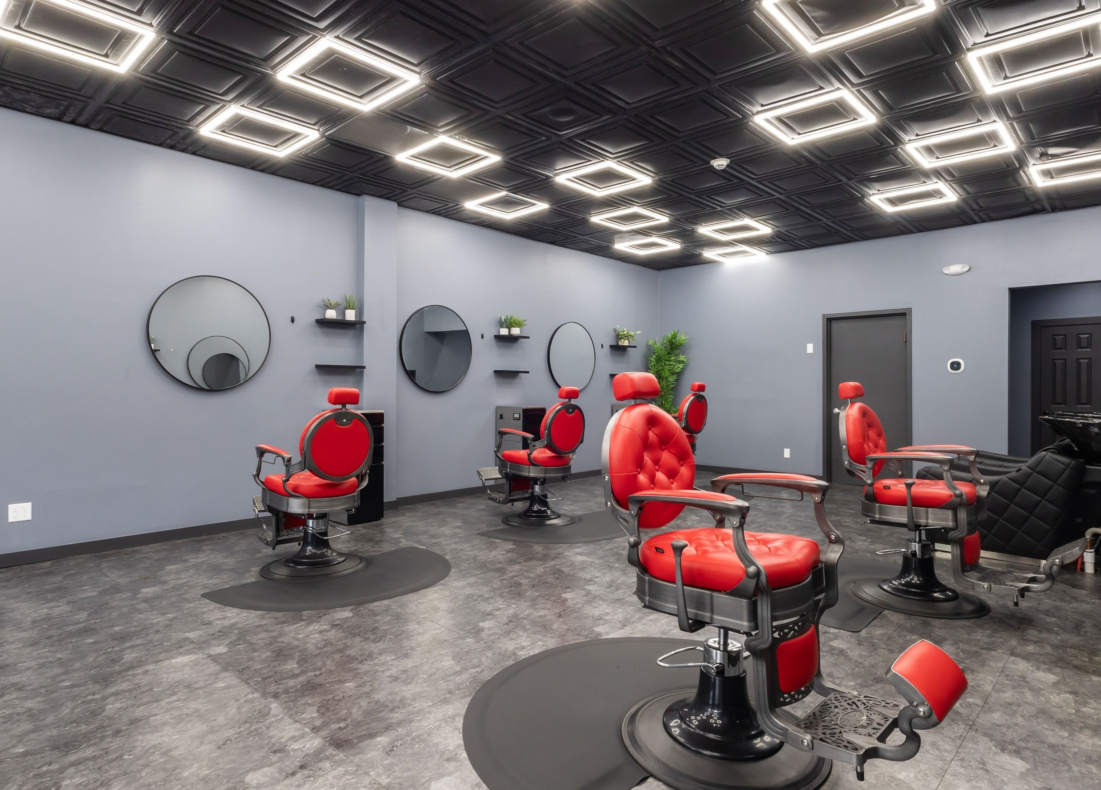 Modern salon interior at YuroCuts Garnerville, Mount Ivy, New York, US featuring red chairs and sleek decor.