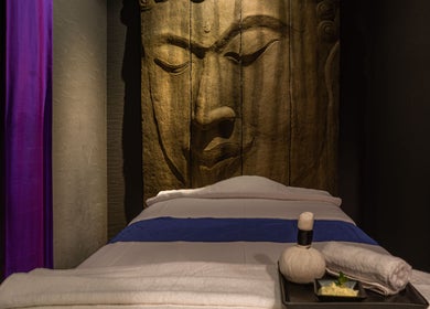Tranquil massage bed at SENSASIA - The Village in Dubai, Dubai, AE, with a serene Buddha backdrop.