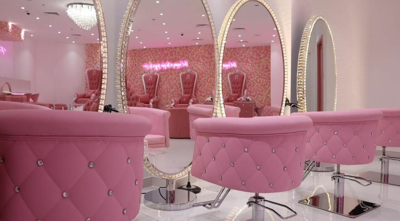 Elegant pink salon interior at Pink Plastic Women Salon, Dubai, AE with plush seating and sparkling mirrors.
