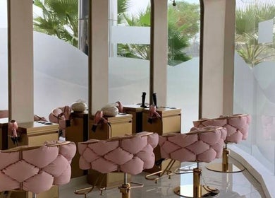 Elegant interior of Pink Plastic Women Salon Business Bay, Dubai, AE with plush pink chairs and large mirrors.
