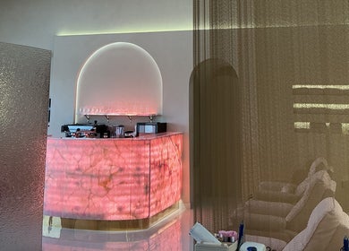 Elegant lounge area at Pink Plastic Women Salon Business Bay, Dubai, Dubai, AE with a glowing pink counter.