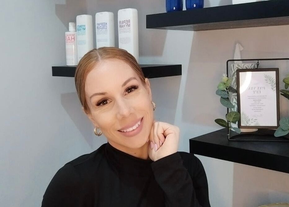 A welcoming stylist at Hair Vogue Salon, Hillcrest, Kwazulu-natal, ZA, surrounded by premium hair products.