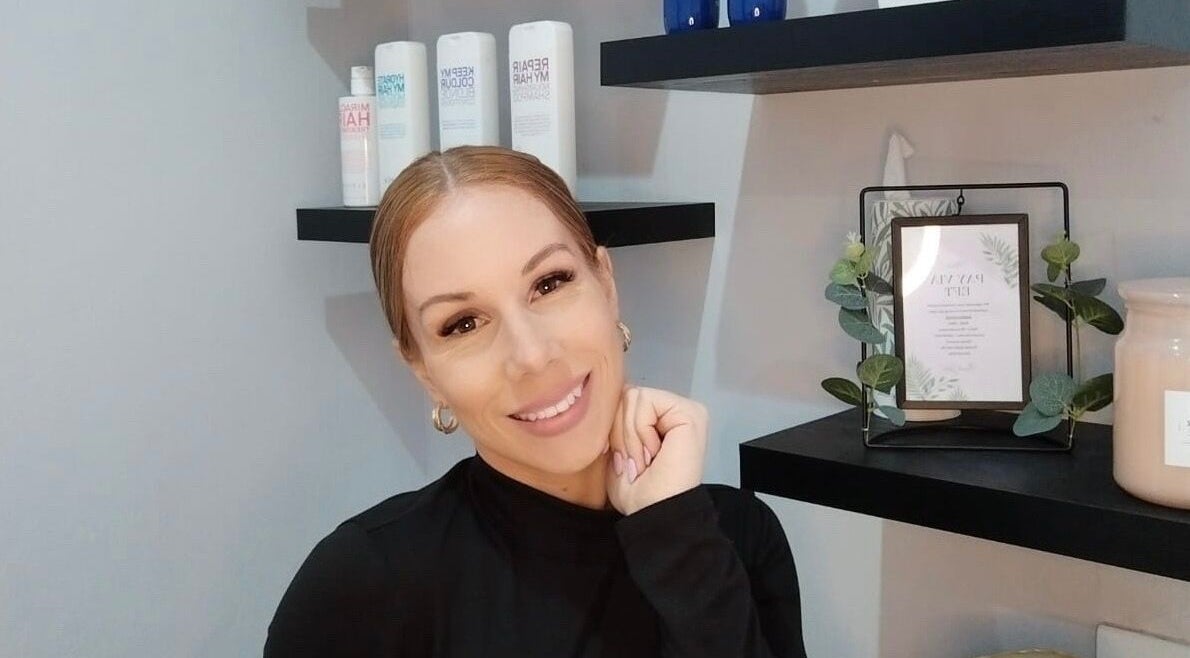 A welcoming stylist at Hair Vogue Salon, Hillcrest, Kwazulu-natal, ZA, surrounded by premium hair products.