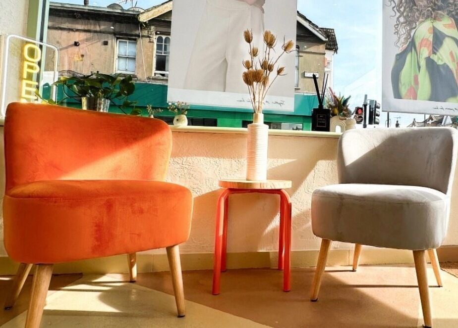 Bright seating area at Getty Space, London, England, GB with orange and gray chairs by the window.