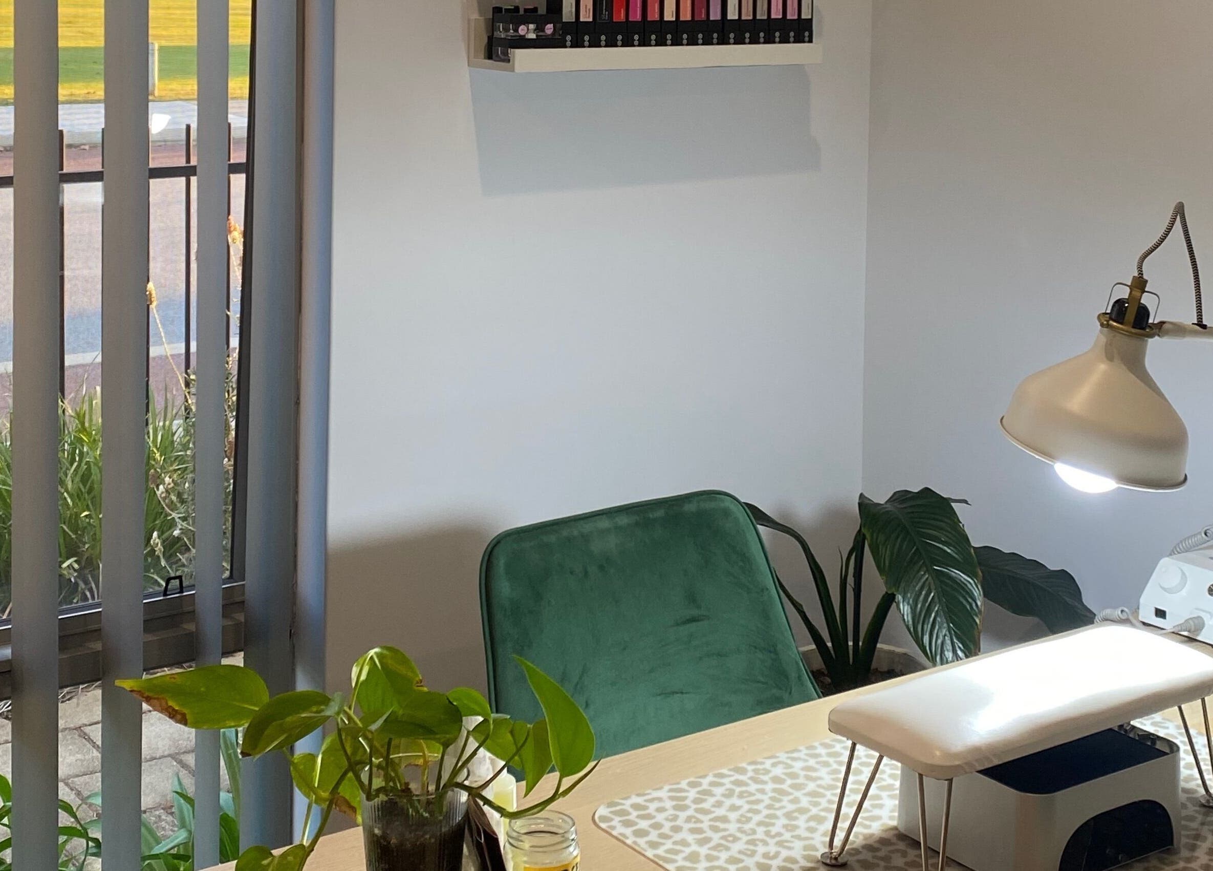 Cozy nail station at Reset Wellness Studio, Baldivis, Western Australia, featuring a green chair and indoor plants.