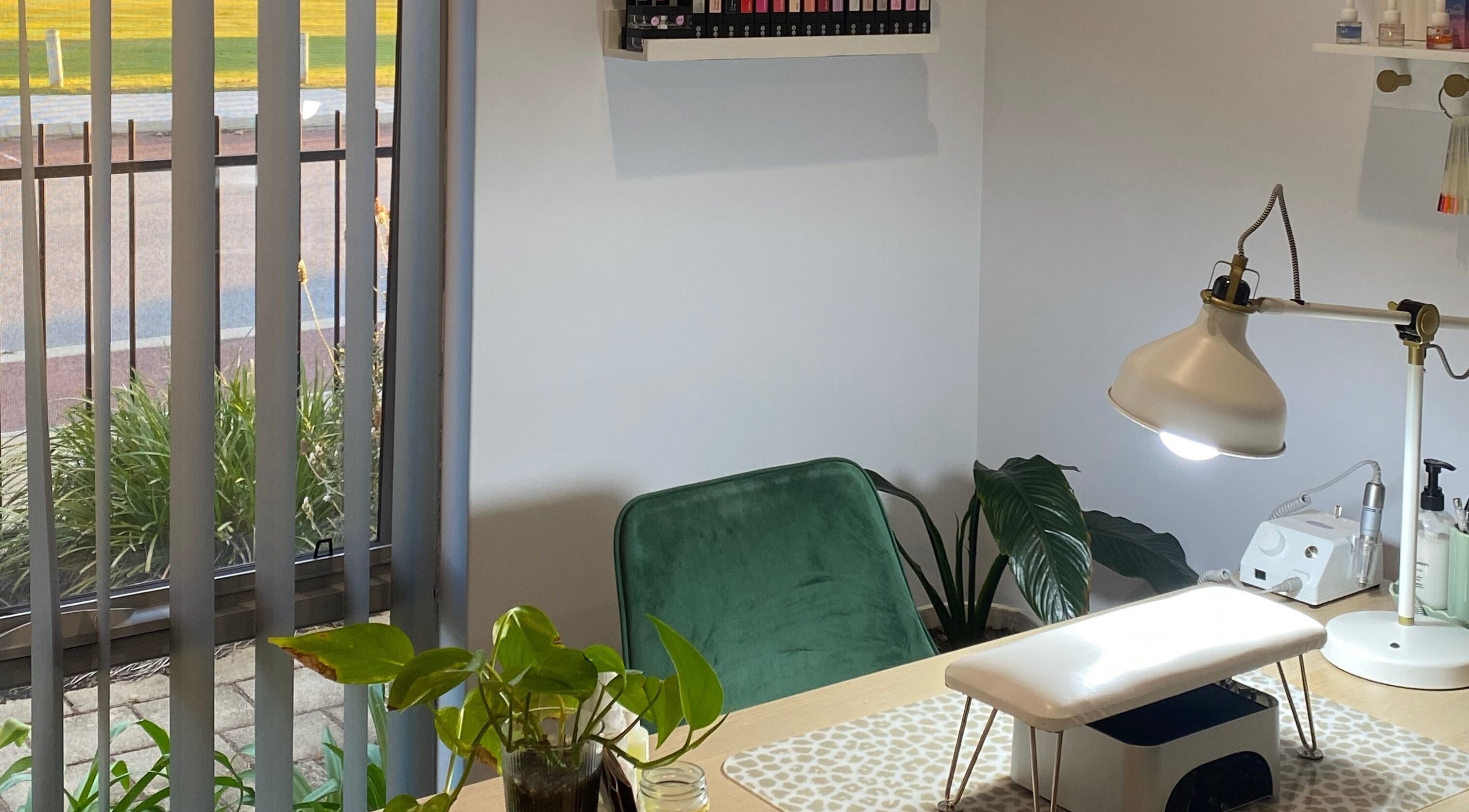Cozy nail station at Reset Wellness Studio, Baldivis, Western Australia, featuring a green chair and indoor plants.