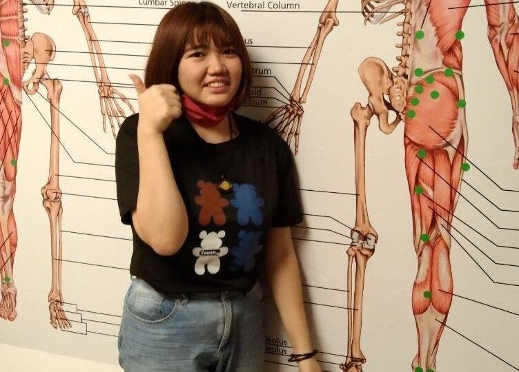 Person at Advanced Muscle Therapy, Petaling Jaya, Selangor, MY, posing by anatomical wall chart.