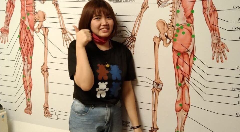 Person at Advanced Muscle Therapy, Petaling Jaya, Selangor, MY, posing by anatomical wall chart.