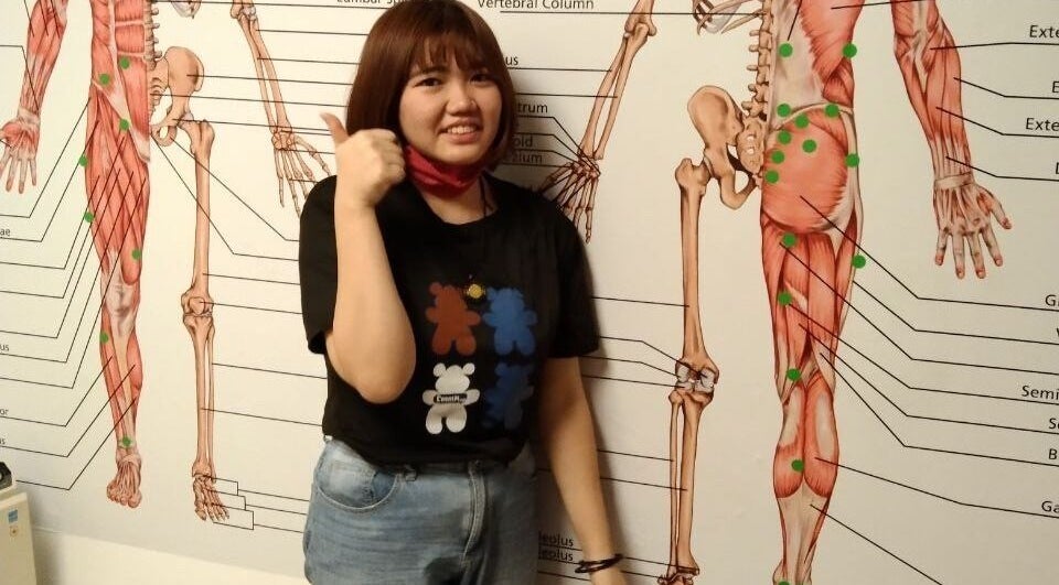 Person at Advanced Muscle Therapy, Petaling Jaya, Selangor, MY, posing by anatomical wall chart.