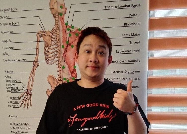 Person giving thumbs up at Advanced Muscle Therapy, Petaling Jaya, Selangor, MY in front of anatomy chart.